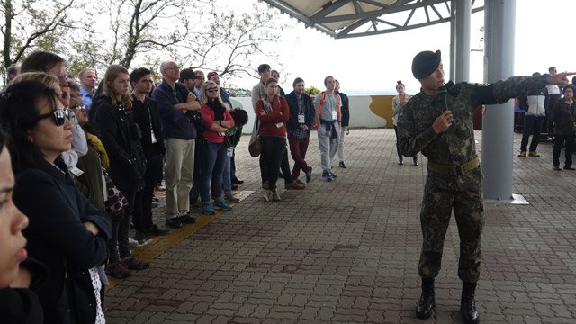 Một binh sỹ Hàn Quốc đang giới thiệu các điểm bên kia đường biên giới với Triều Tiên có thể quan sát được bằng kính viễn vọng.