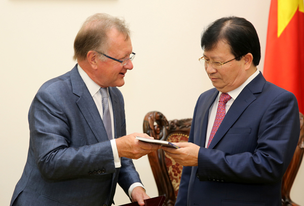 GS. John A. Quelch tặng Phó Thủ tướng Trịnh Đình Dũng cuốn sách mới nhất của mình về phát triển thương hiệu quốc gia. Ảnh: VGP/Xuân Tuyến