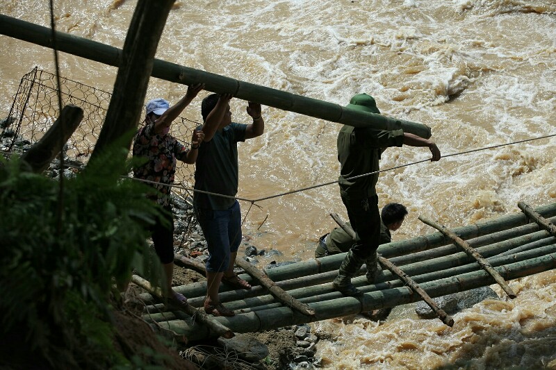 
Bộ đội, dân quân tự vệ huyện Bát Xát khẩn trương làm cầu tre tạm qua suối nhưng rất khó khăn do địa hình dốc, nguy hiểm.

