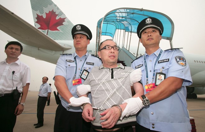 Lại Xương Tinh, nghi phạm hối lộ bị Trung Quốc truy nã quốc tế, được áp giải từ Canada về Bắc Kinh năm 2011. Ảnh: Reuters