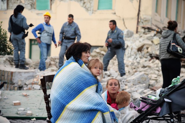 
Những người sống sót thẫn thờ bên đống đổ nát của ngôi nhà họ tại thị trấn Amatrice, nơi chịu thiệt hại nặng nề nhất
