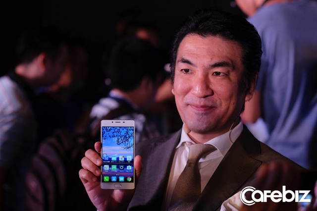 
Ông Kaoru Masuda bên một mẫu smartphone ra mắt lần này.
