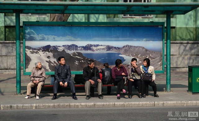 
Trong tấm hình này là những người làm việc cho một văn phòng ngồi chờ xe buýt, phương tiện công cộng được sử dụng nhiều hơn cả ở Triều Tiên.
