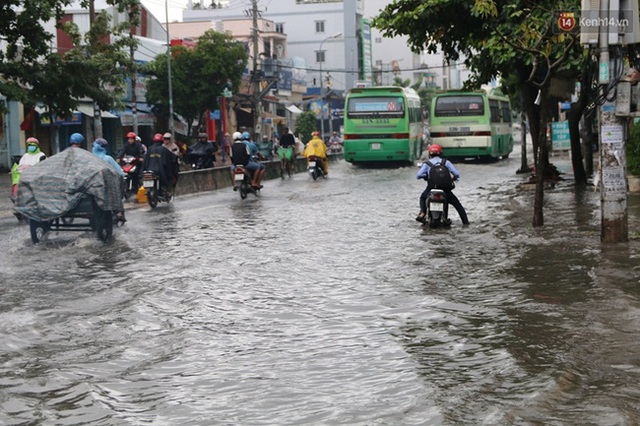 
Nhiều người chật vật đi qua đoạn đường ngập nước
