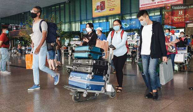 Chùm ảnh: Người dân mặc đồ bảo hộ kín mít trên những chuyến bay trở về Sài Gòn sau kỳ nghỉ Tết nguyên đán - Ảnh 1.