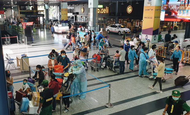 Chùm ảnh: Người dân mặc đồ bảo hộ kín mít trên những chuyến bay trở về Sài Gòn sau kỳ nghỉ Tết nguyên đán - Ảnh 4.