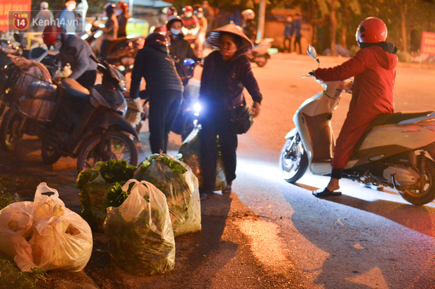 Ảnh: Đường vào thôn bị phong toả, người dân Mê Linh chuyển hàng tạ rau qua chốt kiểm dịch y tế trong đêm - Ảnh 1.