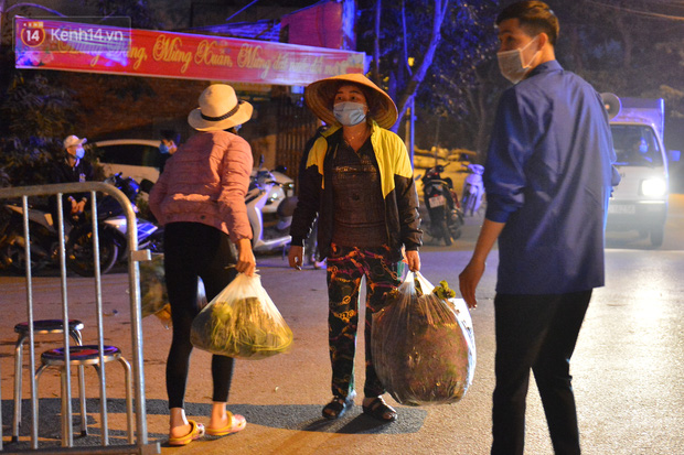 Ảnh: Đường vào thôn bị phong toả, người dân Mê Linh chuyển hàng tạ rau qua chốt kiểm dịch y tế trong đêm - Ảnh 2.