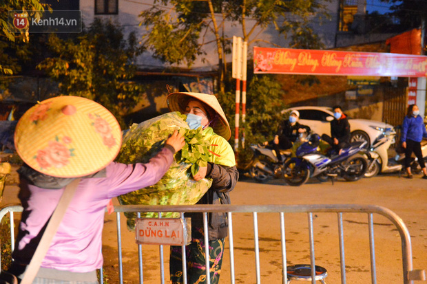 Ảnh: Đường vào thôn bị phong toả, người dân Mê Linh chuyển hàng tạ rau qua chốt kiểm dịch y tế trong đêm - Ảnh 3.