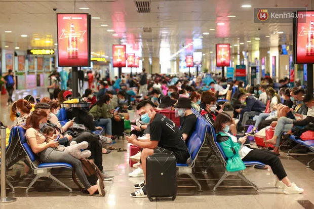Tối 27 tháng Chạp ở Tân Sơn Nhất: Hành khách mặc áo mưa, đồ bảo hộ kín mít chờ về quê đón Tết - Ảnh 1.