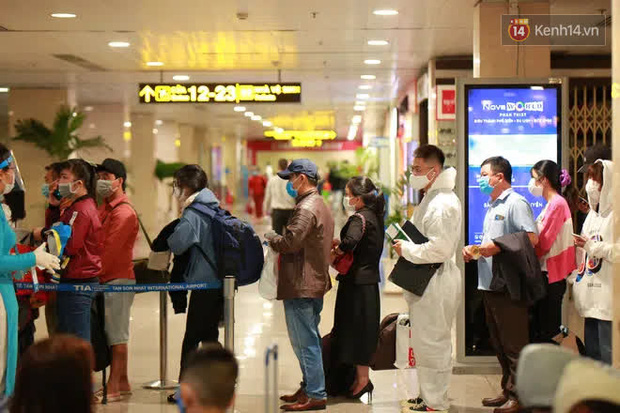 Tối 27 tháng Chạp ở Tân Sơn Nhất: Hành khách mặc áo mưa, đồ bảo hộ kín mít chờ về quê đón Tết - Ảnh 2.