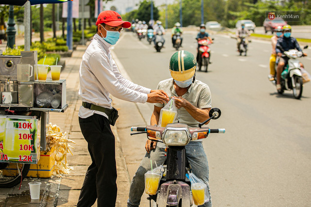  Chùm ảnh: Công nhân vật lộn với cái nóng hầm hập ở Sài Gòn, người đi đường mặc cả áo mưa tránh nắng  - Ảnh 18.