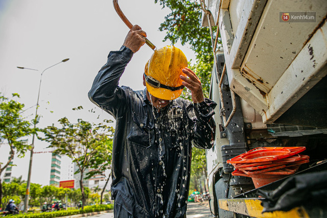  Chùm ảnh: Công nhân vật lộn với cái nóng hầm hập ở Sài Gòn, người đi đường mặc cả áo mưa tránh nắng  - Ảnh 4.