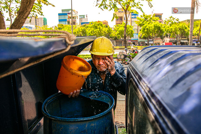  Chùm ảnh: Công nhân vật lộn với cái nóng hầm hập ở Sài Gòn, người đi đường mặc cả áo mưa tránh nắng  - Ảnh 5.