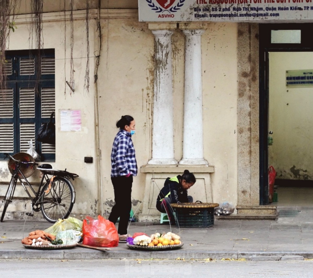 Người lao động đường phố Hà Nội quay quắt mưu sinh dưới mưa rét - Ảnh 1.