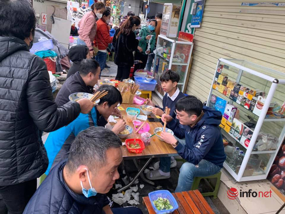 Quán bún ở Hà Nội bé tẹo, chỉ 1m2 thuê 16 nhân viên, bán nghìn bát mỗi ngày, khách ngồi kín vỉa hè chờ ăn trong giá rét - Ảnh 1. Quán bún ở Hà Nội bé tẹo, chỉ 1m2 thuê 16 nhân viên, bán nghìn bát mỗi ngày, khách ngồi kín vỉa hè chờ ăn trong giá rét - Ảnh 1.