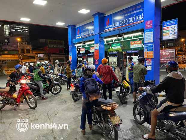  Đã đêm muộn, rất đông người dân vẫn xếp hàng dài, mang thêm bình nhựa để mua xăng trước kỳ tăng giá - Ảnh 1.
