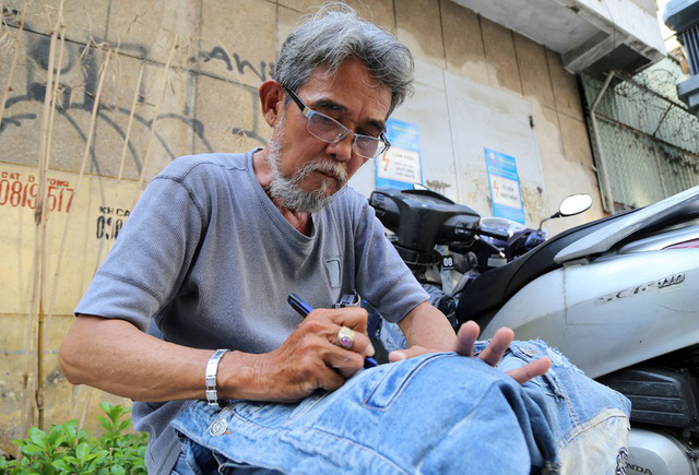   The unique job of tearing jeans on the sidewalks of Ho Chi Minh City - Photo 1.