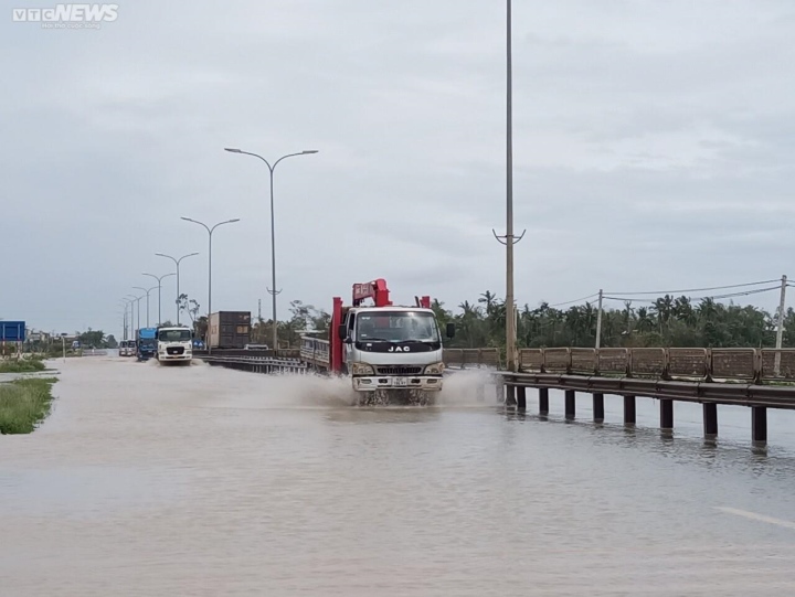 Ảnh: Quốc lộ 1A, tuyến đường ven sông Hoài ở phố cổ Hội An ngập sâu sau bão Noru - Ảnh 1.