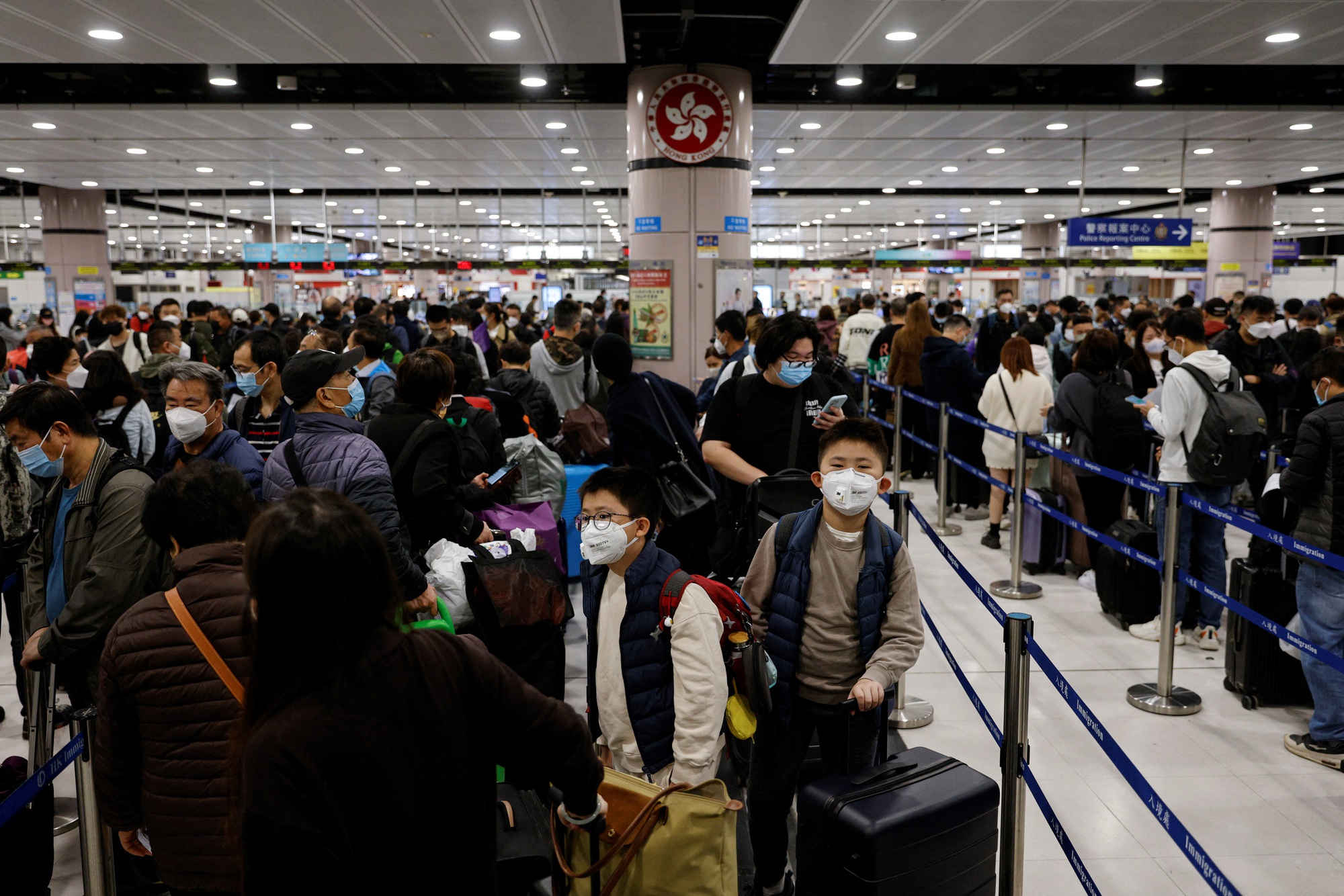 Hành khách xếp hàng tại trạm kiểm soát Lok Ma Chau ở Hong Kong trong ngày đầu mở cửa ngày 8-1 - Ảnh: REUTERS