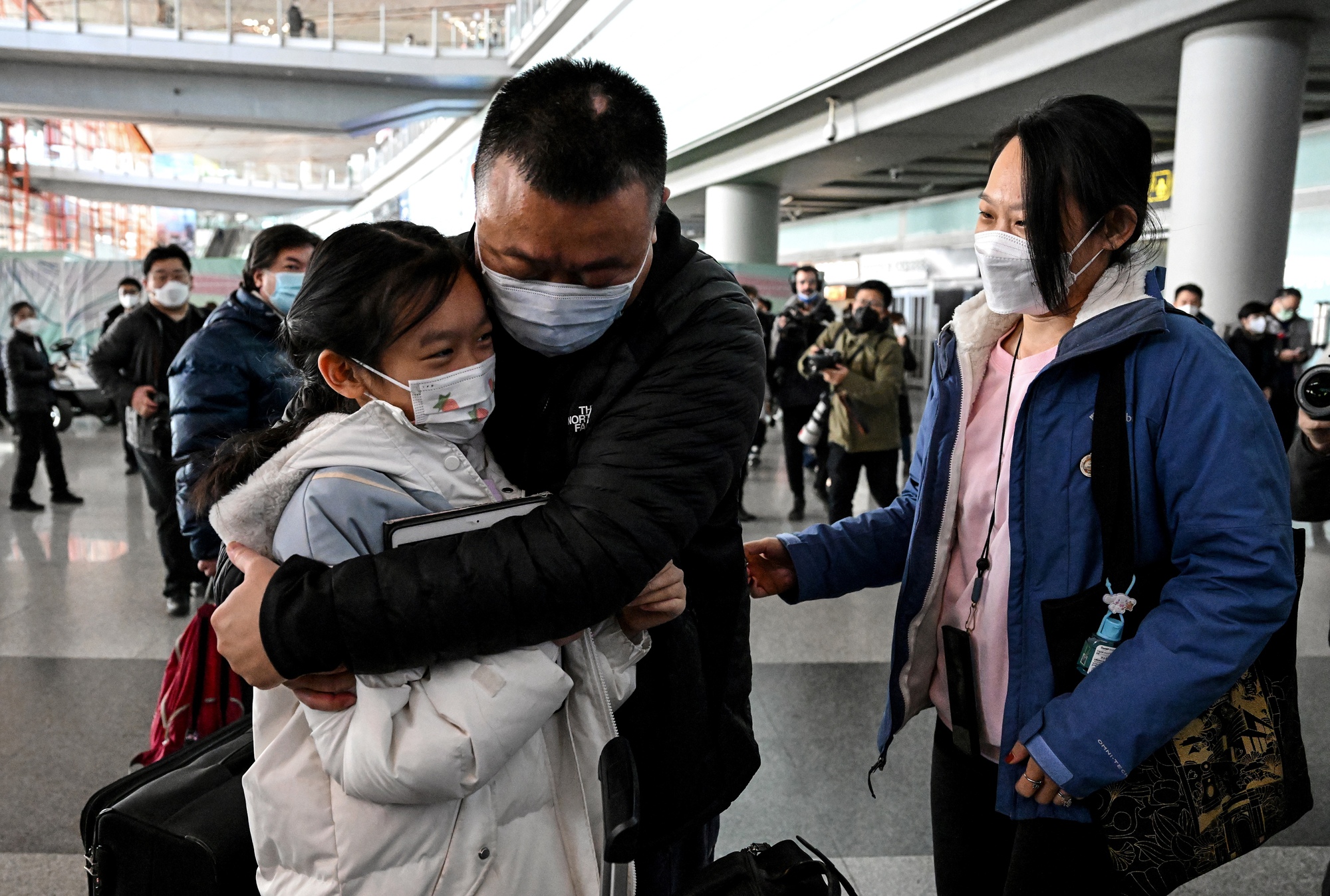 Một người cha đoàn tụ cùng con gái ở sân bay Bắc Kinh ngày 8-1 - Ảnh: AFP