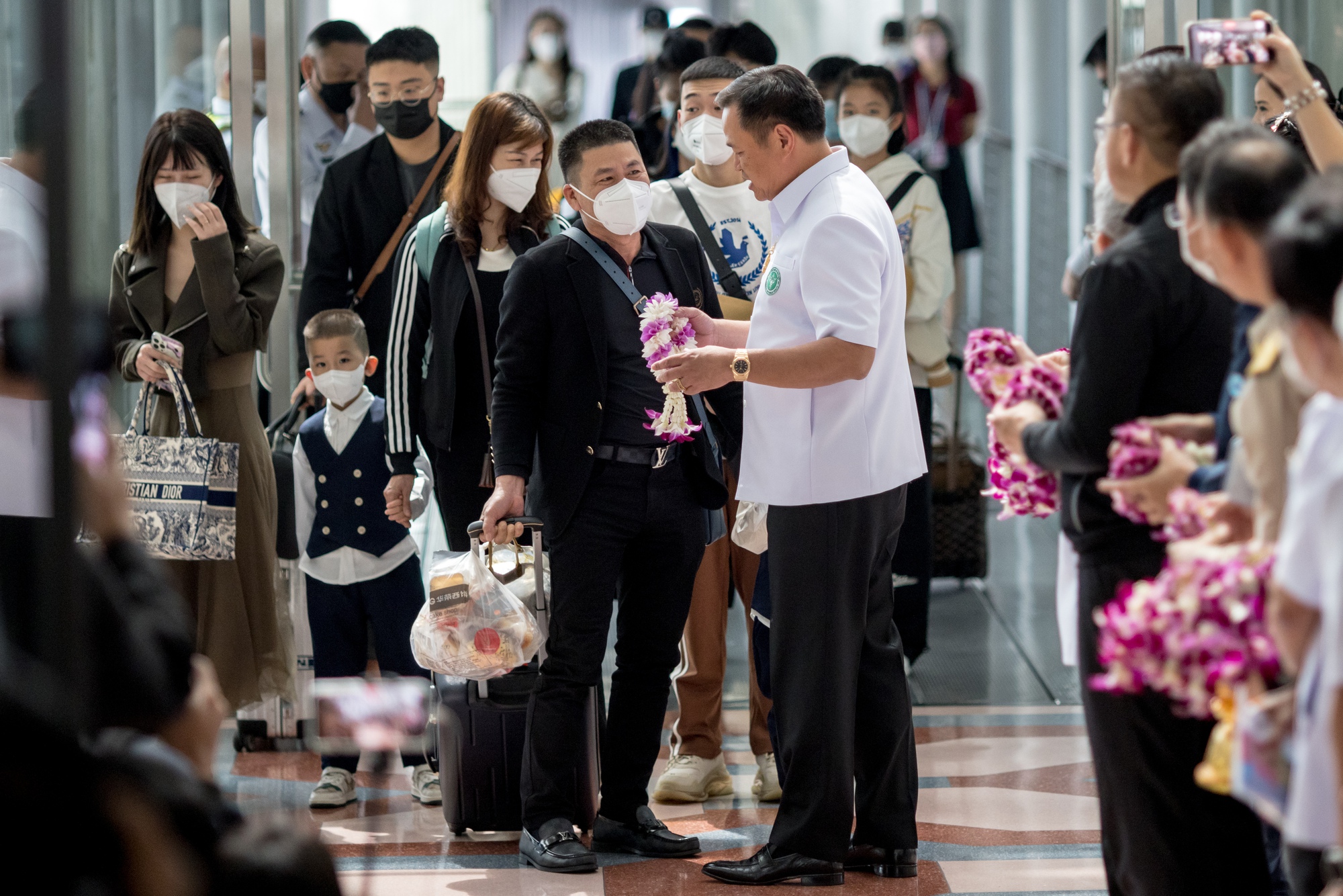 Bộ trưởng Du lịch Thái Lan Anutin Charnvirakul đón các du khách Trung Quốc đến Bangkok ngày 9-1 - Ảnh: AFP