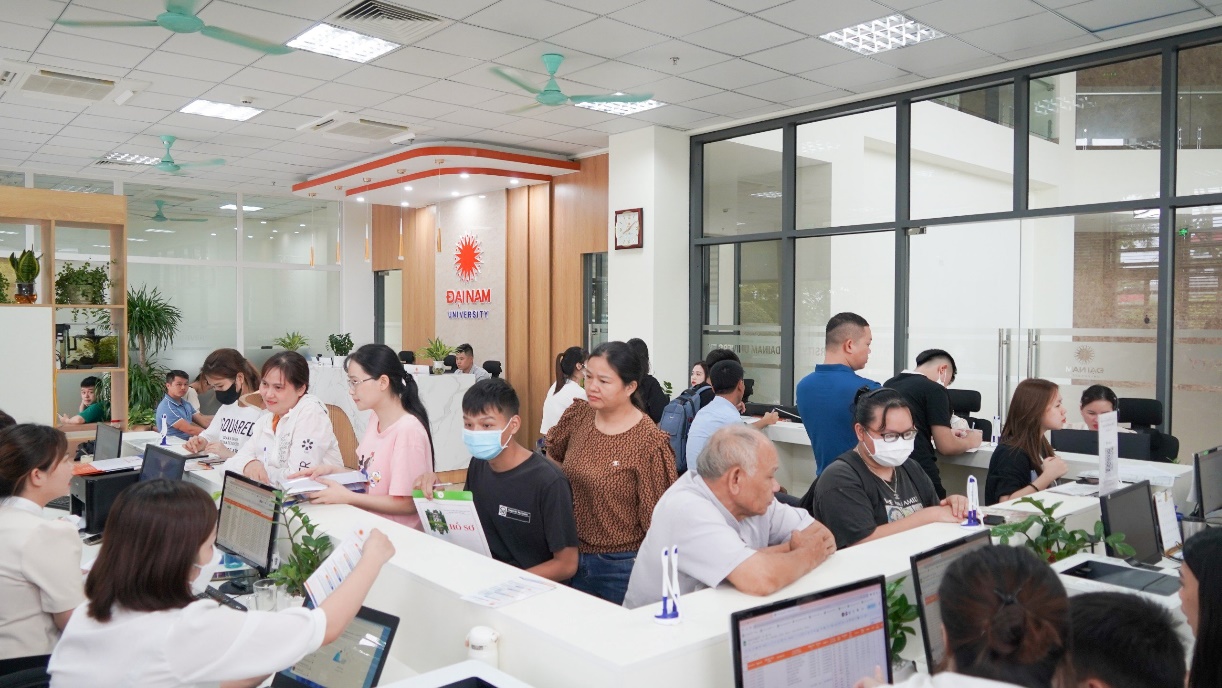 A group of people in a room with computers Description automatically generated