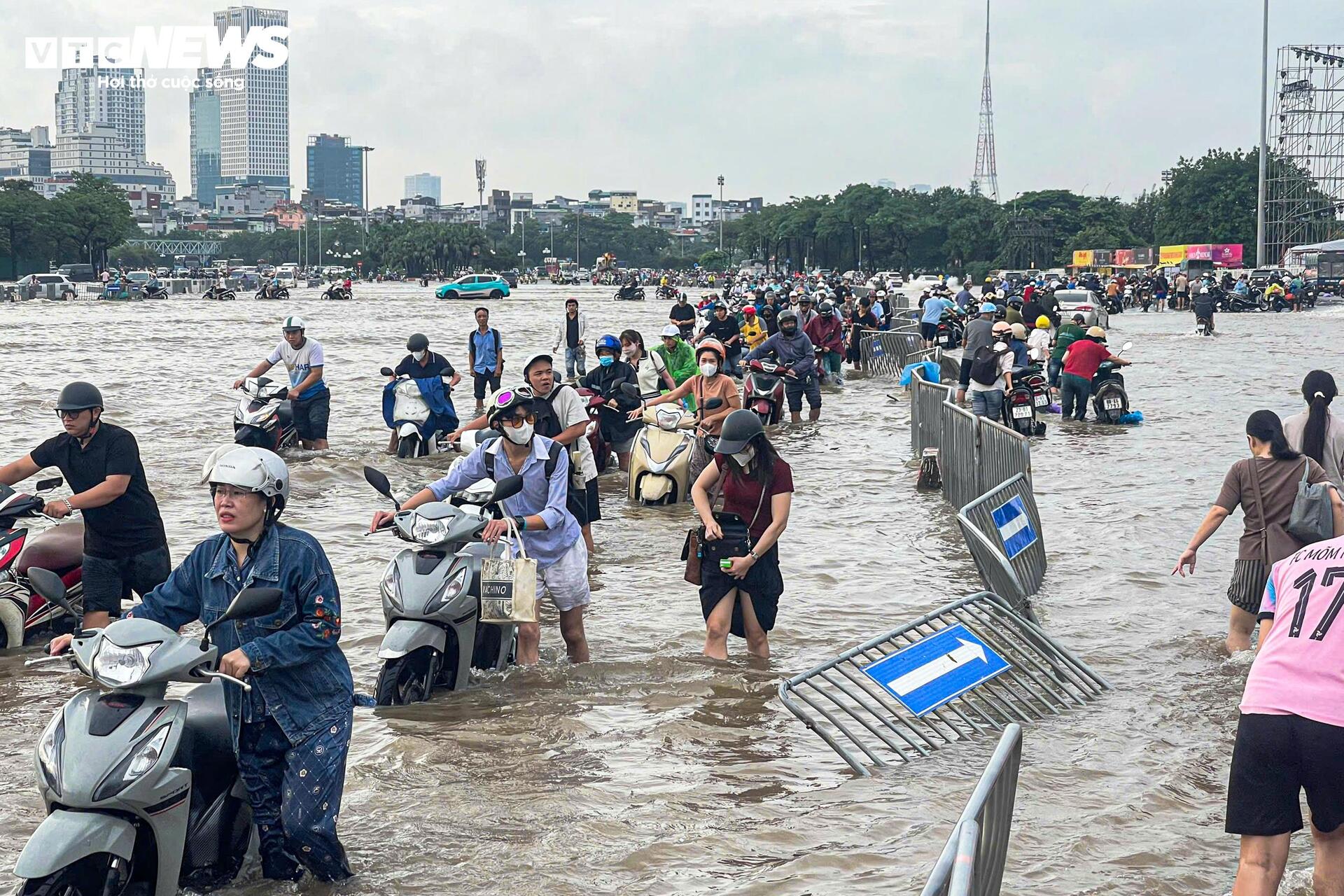 Đường vẫn ngập ngang gối, dân Hà Nội chen chúc dắt xe lội nước đi làm từ sớm Đường vẫn ngập ngang gối, dân Hà Nội chen chúc dắt xe lội nước đi làm từ sớm