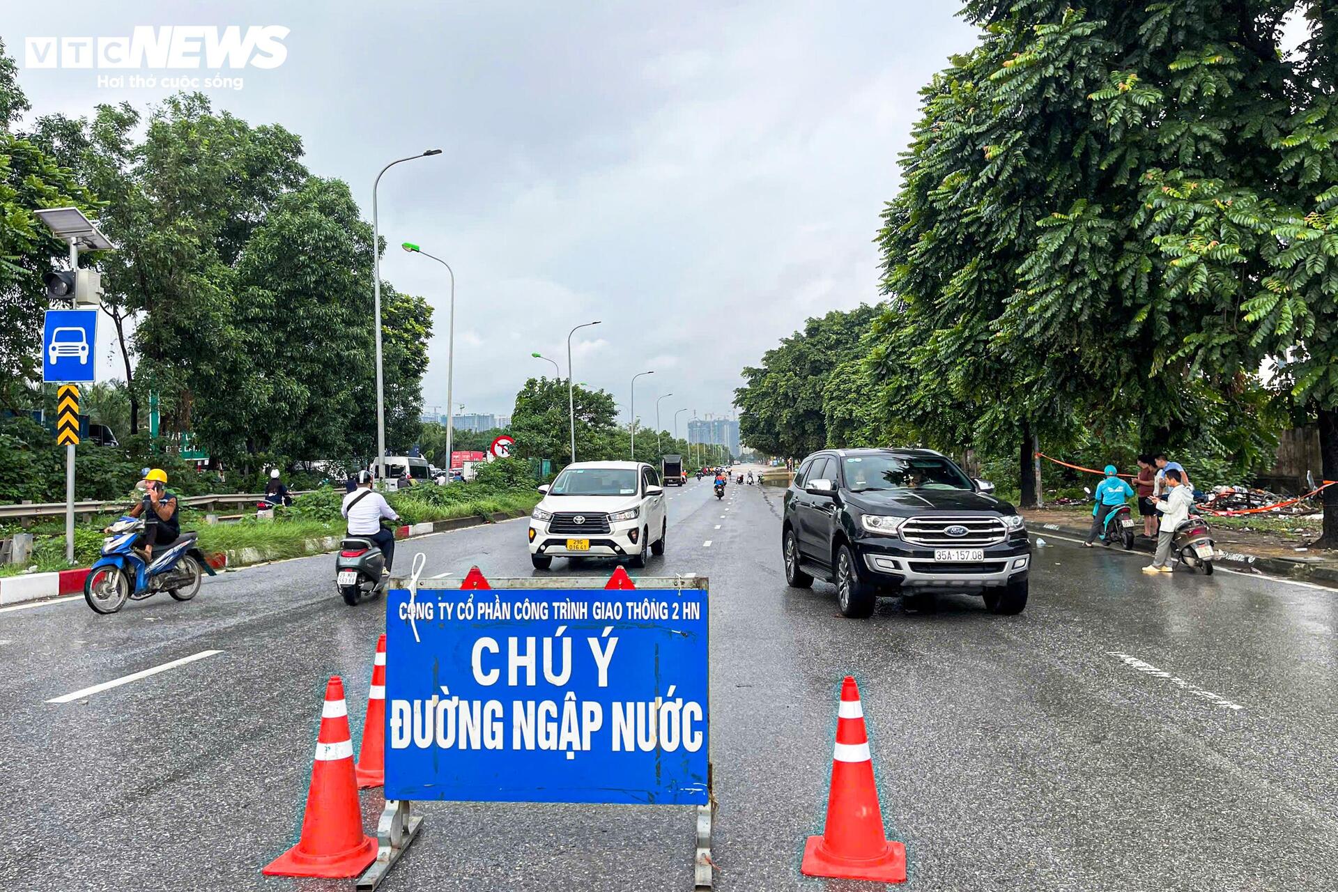 Đường vẫn ngập ngang gối, dân Hà Nội chen chúc dắt xe lội nước đi làm từ sớm Đường vẫn ngập ngang gối, dân Hà Nội chen chúc dắt xe lội nước đi làm từ sớm