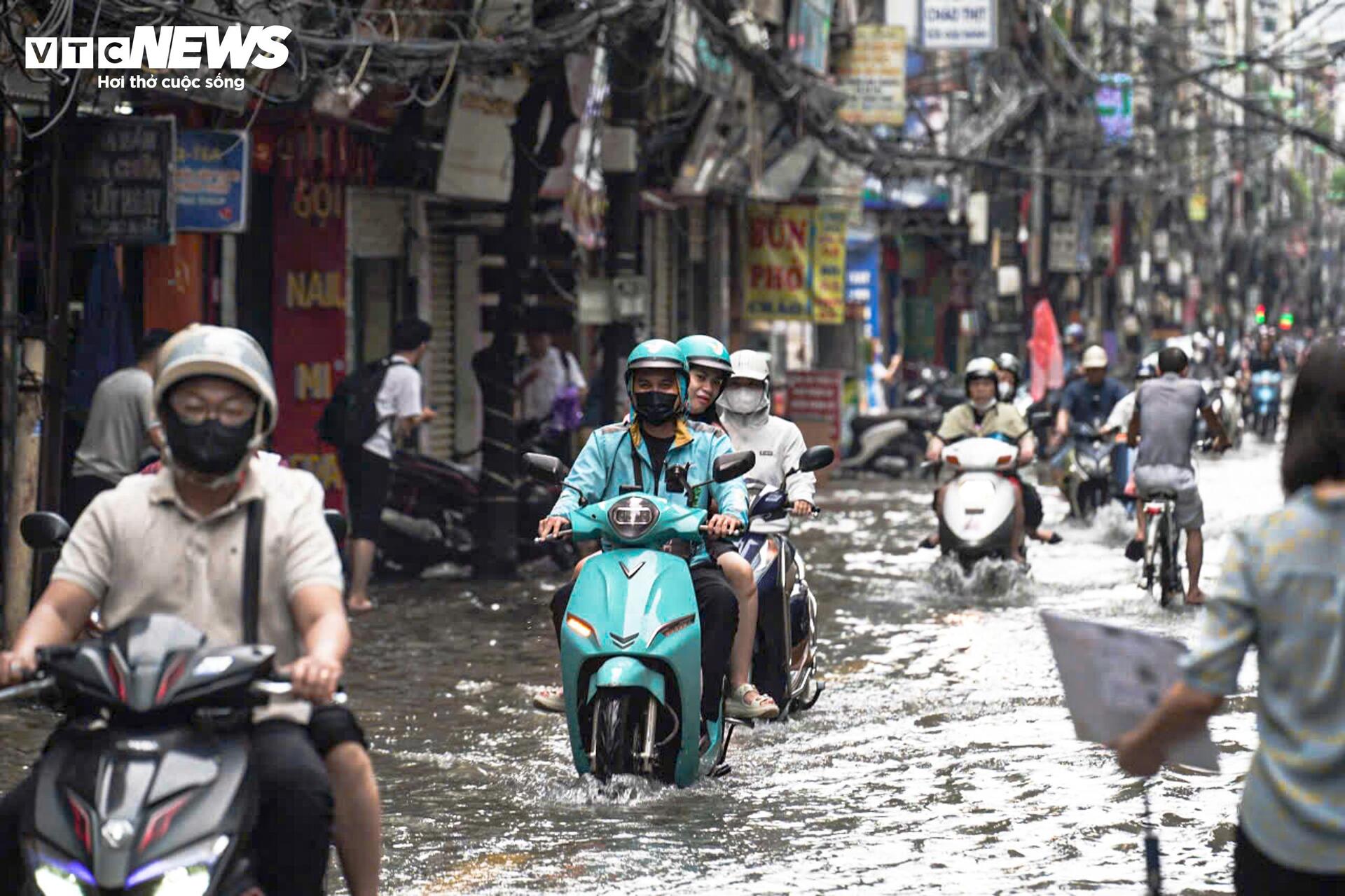 Đường vẫn ngập ngang gối, dân Hà Nội chen chúc dắt xe lội nước đi làm từ sớm Đường vẫn ngập ngang gối, dân Hà Nội chen chúc dắt xe lội nước đi làm từ sớm