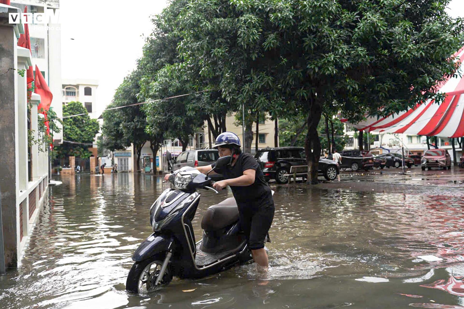 Đường vẫn ngập ngang gối, dân Hà Nội chen chúc dắt xe lội nước đi làm từ sớm Đường vẫn ngập ngang gối, dân Hà Nội chen chúc dắt xe lội nước đi làm từ sớm