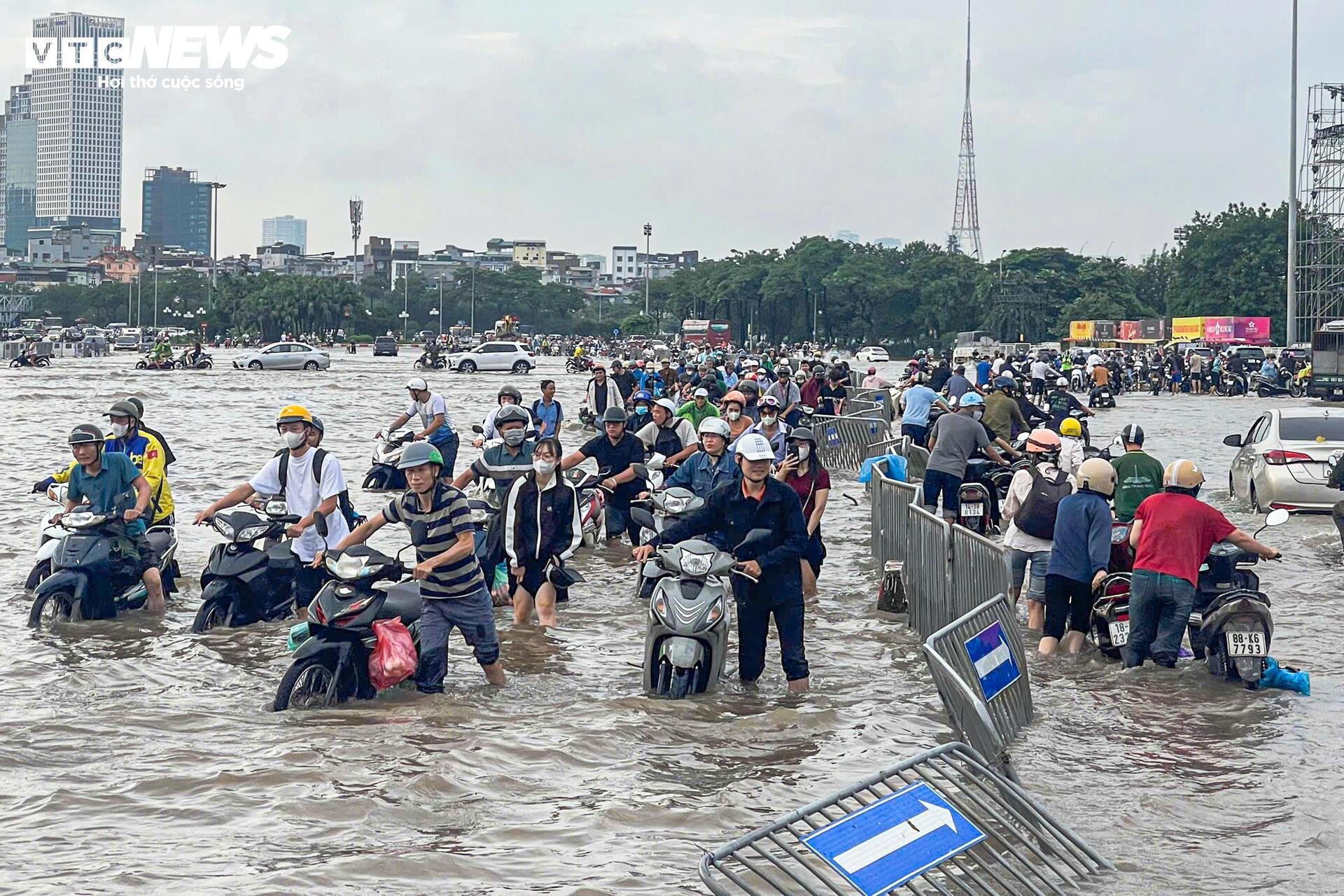Đường vẫn ngập ngang gối, dân Hà Nội chen chúc dắt xe lội nước đi làm từ sớm Đường vẫn ngập ngang gối, dân Hà Nội chen chúc dắt xe lội nước đi làm từ sớm
