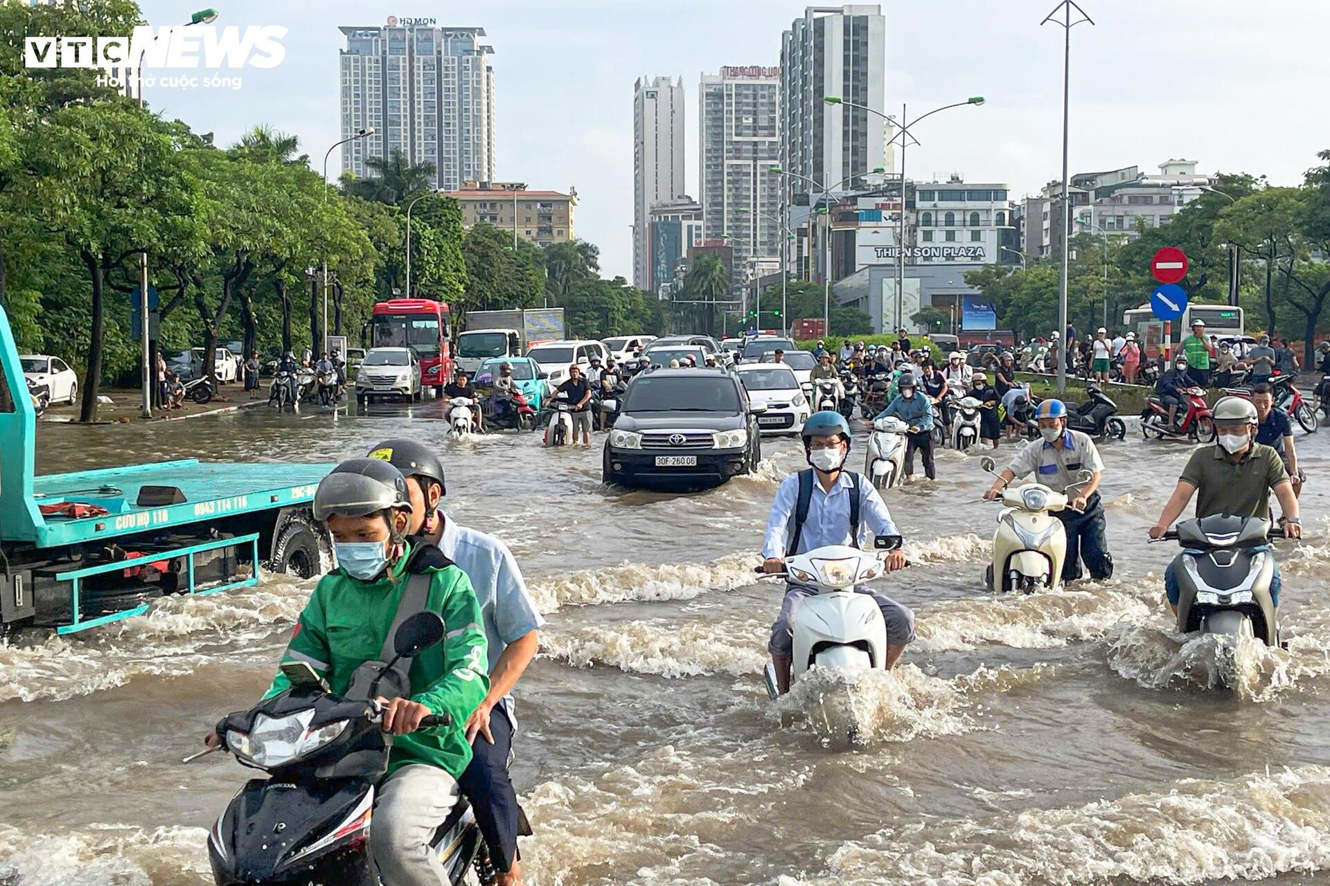 Đường vẫn ngập ngang gối, dân Hà Nội chen chúc dắt xe lội nước đi làm từ sớm Đường vẫn ngập ngang gối, dân Hà Nội chen chúc dắt xe lội nước đi làm từ sớm