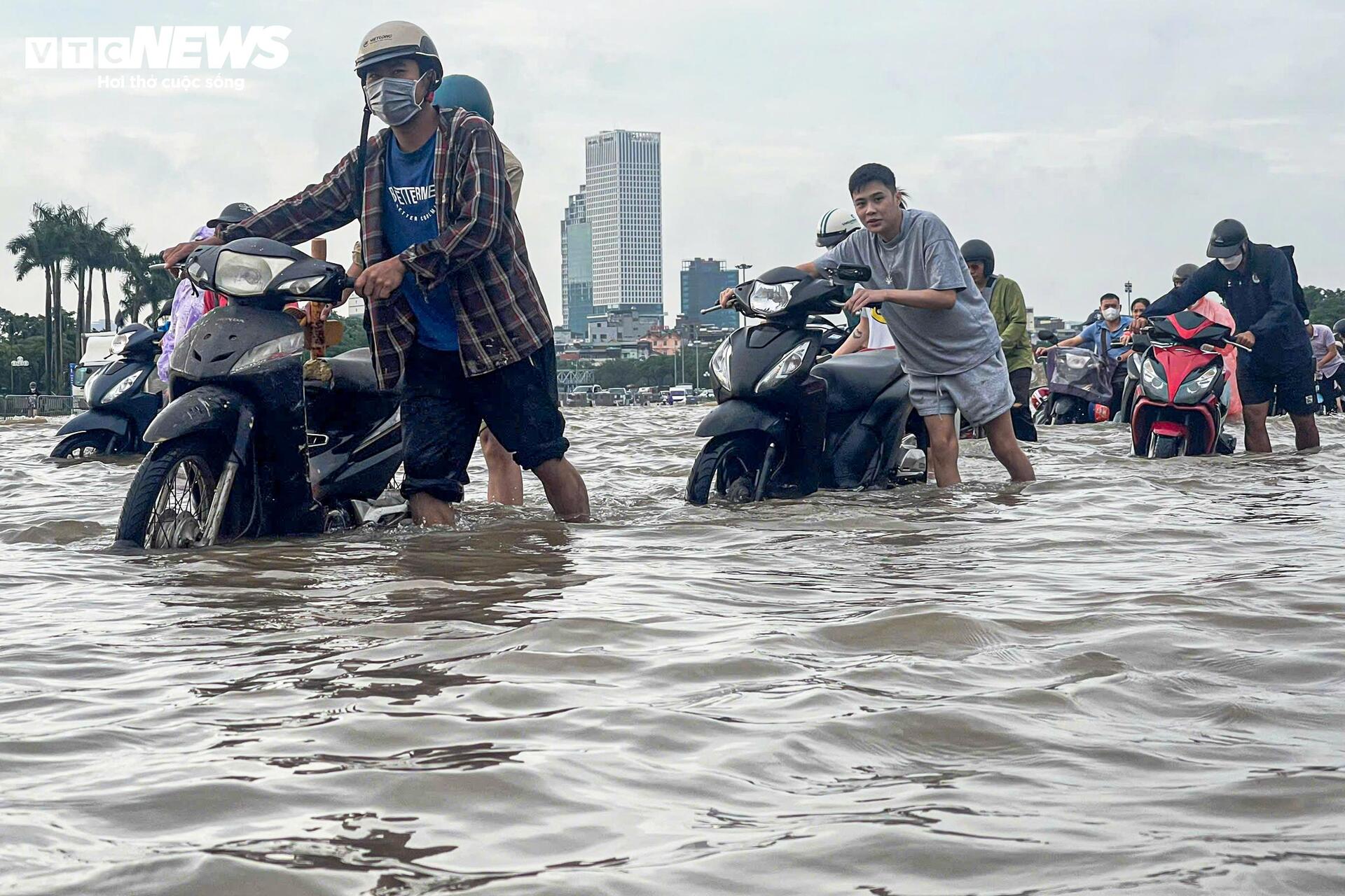 Đường vẫn ngập ngang gối, dân Hà Nội chen chúc dắt xe lội nước đi làm từ sớm Đường vẫn ngập ngang gối, dân Hà Nội chen chúc dắt xe lội nước đi làm từ sớm