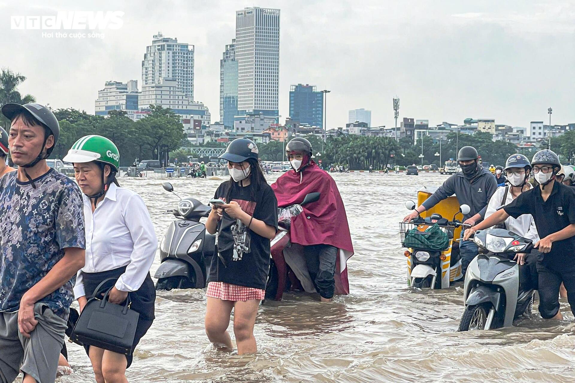 Đường vẫn ngập ngang gối, dân Hà Nội chen chúc dắt xe lội nước đi làm từ sớm Đường vẫn ngập ngang gối, dân Hà Nội chen chúc dắt xe lội nước đi làm từ sớm