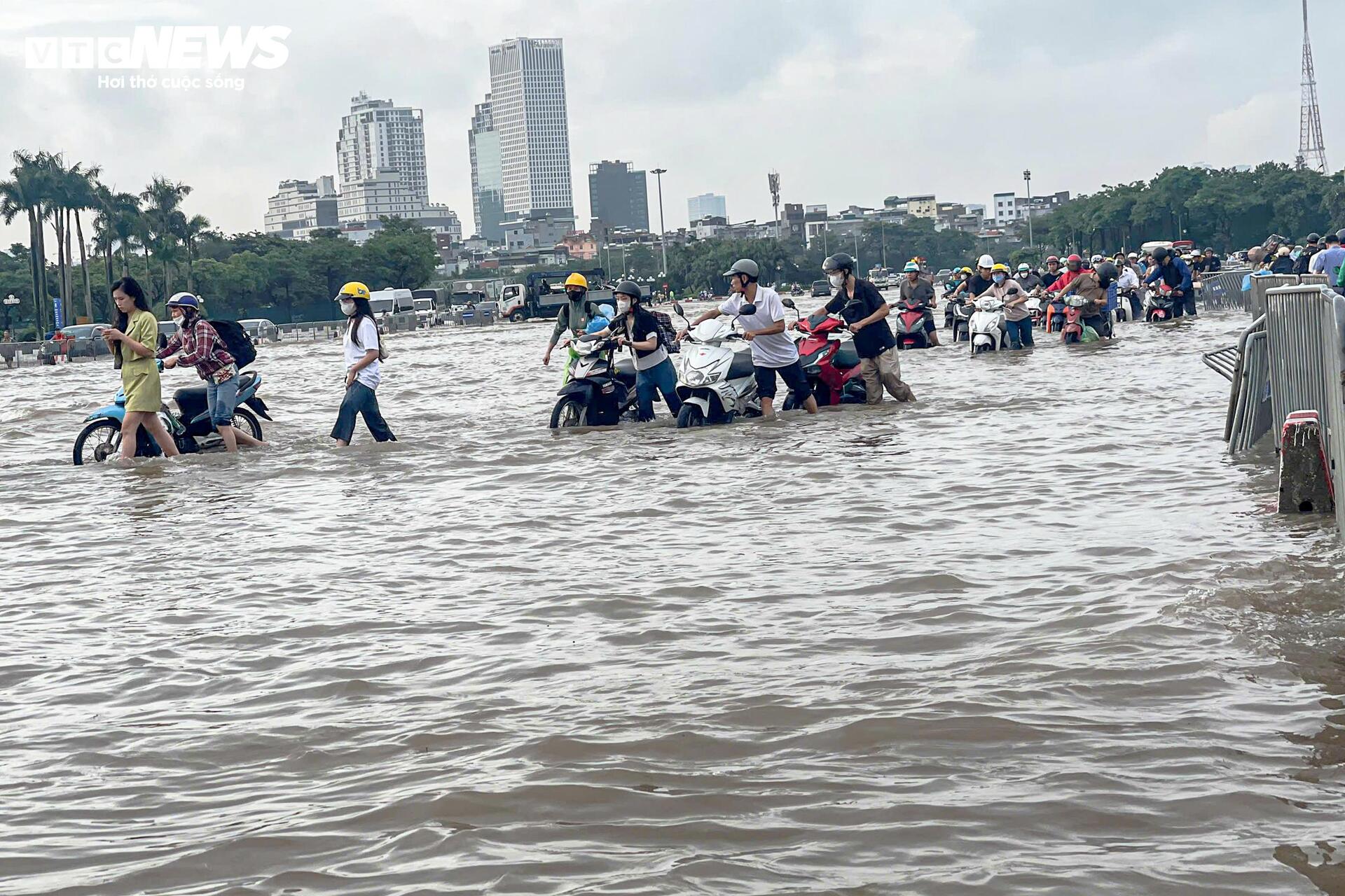 Đường vẫn ngập ngang gối, dân Hà Nội chen chúc dắt xe lội nước đi làm từ sớm Đường vẫn ngập ngang gối, dân Hà Nội chen chúc dắt xe lội nước đi làm từ sớm