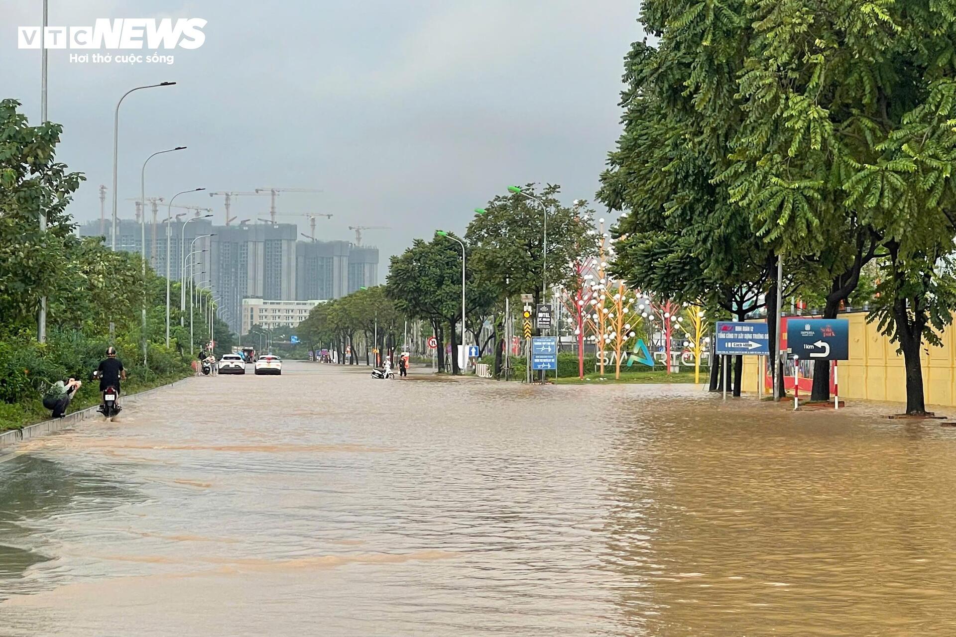 Đường vẫn ngập ngang gối, dân Hà Nội chen chúc dắt xe lội nước đi làm từ sớm Đường vẫn ngập ngang gối, dân Hà Nội chen chúc dắt xe lội nước đi làm từ sớm