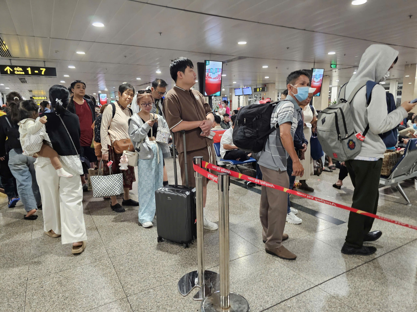 Hành khách chờ đêm tại sân bay Tân Sơn Nhất trong ngày cao điểm Tết 2026 - Ảnh 2.