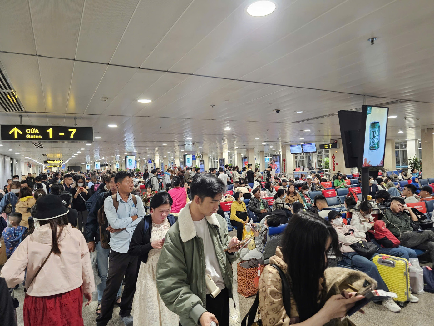 Hành khách chờ đêm tại sân bay Tân Sơn Nhất trong ngày cao điểm Tết 2026 - Ảnh 4.
