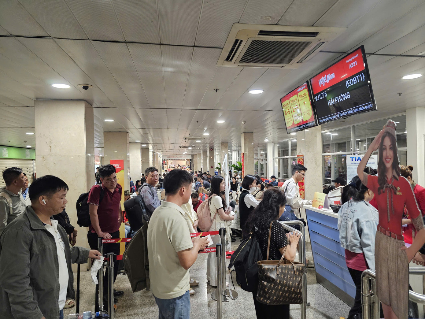 Hành khách chờ đêm tại sân bay Tân Sơn Nhất trong ngày cao điểm Tết 2026 - Ảnh 6.