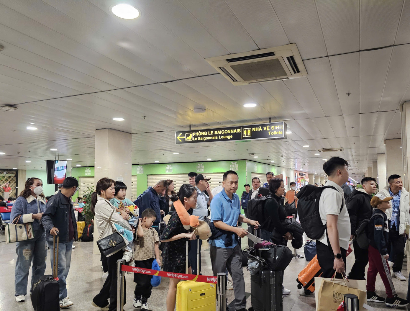 Hành khách chờ đêm tại sân bay Tân Sơn Nhất trong ngày cao điểm Tết 2026 - Ảnh 3.