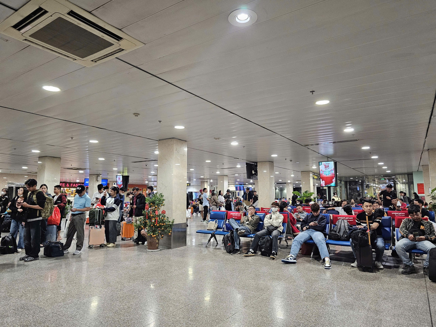 Hành khách chờ đêm tại sân bay Tân Sơn Nhất trong ngày cao điểm Tết 2026 - Ảnh 9.