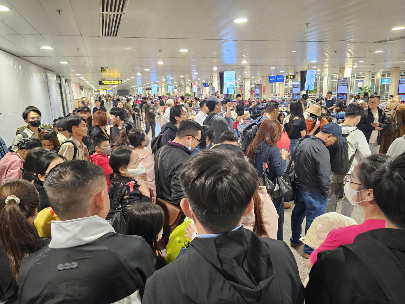 Hành khách chờ đêm tại sân bay Tân Sơn Nhất trong ngày cao điểm Tết 2026 - Ảnh 5.
