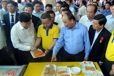 Thủ tướng Nguyễn Xuân Phúc tham quan gian hàng sản phẩm tôm của Tập đoàn Minh Phú (Cà Mau).