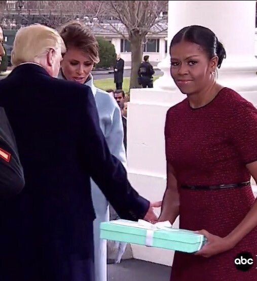 
Bà Obama không được tự nhiên lắm khi nhận món quà từ bà Melania.
