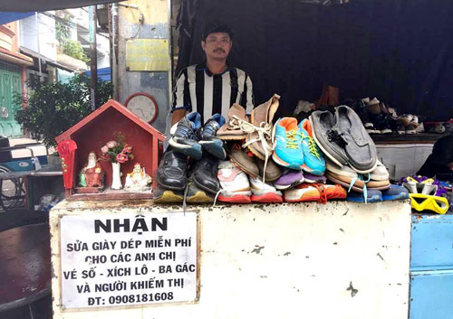 Anh Huỳnh Thanh Tuấn bên tiệm sửa giày của mình.