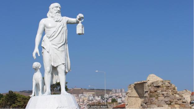 Bức tượng của nhà triết học Diogenes được đặt ở trung tâm thành phố như một lời nhắn nhủ tới mọi người hãy tôn trọng lối sống thuận tự nhiên mà ông đã từng theo đuổi.