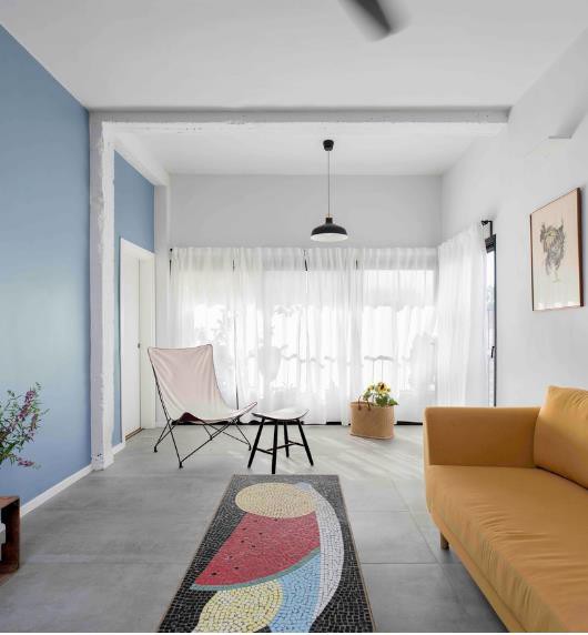 Chiếc thảm trải sàn nhiều màu lạ mắt cùng bức tường sơn xanh cũng là những điểm nhân bắt mắt cho bất kỳ ai bước chân vào nhà.
