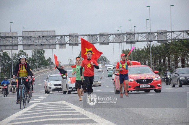  Chùm ảnh: Người hâm mộ cầm cờ Tổ quốc, chạy bộ ra sân bay Nội Bài để đón U23 Việt Nam  - Ảnh 4.