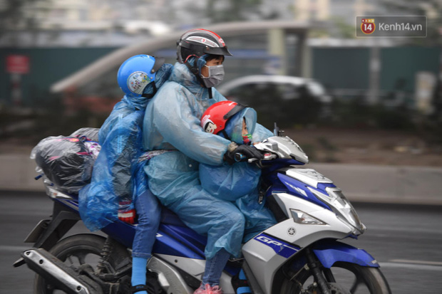 Chùm ảnh: Trẻ nhỏ trùm chăn, khoác áo mưa chật vật theo chân bố mẹ rời Thủ đô về quê ăn Tết - Ảnh 1.